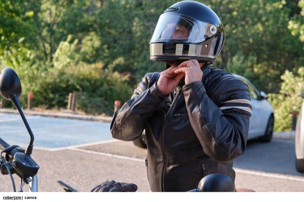 Imagen de una persona en una moto nueva, sosteniendo el casco y sonriendo