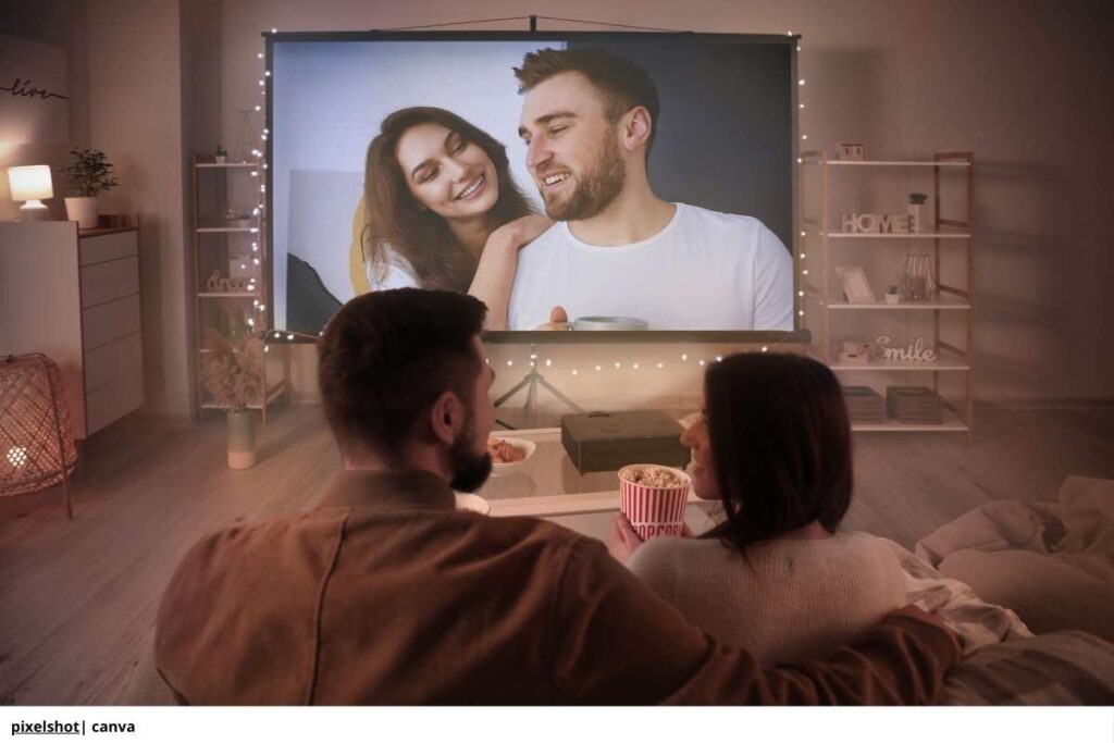 Una pareja viendo una película de forma romántica en el cine